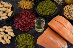 Plusieurs aliments riches en fer disposés sur une table avec un verre d'eau au centre.